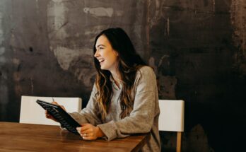 woman sitting around table holding tablet