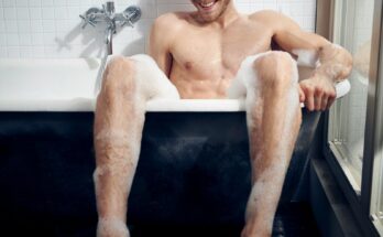 topless man sitting on bathtub